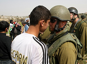 Manifestante palestino confronta soldado israelense após aviso para ativistas não se aproximarem de assentamento judaico