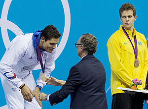 Cesar Cielo observa o presidente do COB entregar a medalha de ouro para Florent Manaudou