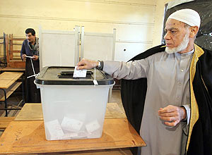 Egípcio deposita voto em urna em segunda fase de referendo para nova Constituição em Giza; texto causa protestos no país