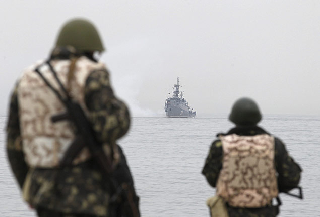 Soldados ucranianos observam navio de guerra russo em Sebastopol