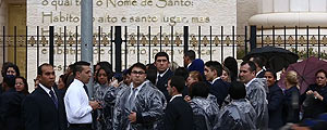 Obreiros tomam chuva enquanto esperam para entrar no templo (Carlos Cecconello/Folhapress) Obreiros tomam chuva enquanto esperam para entrar no templo (Carlos Cecconello/Folhapress)