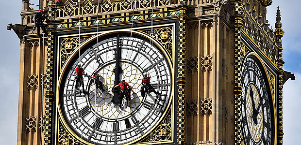TOPSHOTS Technicians carry out cleaning and maintenance work on one of the faces of the Great Clock atop the landmark Elizabeth Tower that houses Big Ben, attached to the Houses of Parliament, in London, on August 19, 2014. A team of abseilers is busy this week cleaning up the clock faces at the Houses of Parliament in London. The specialist technicians descend the most famous London landmark by rope to clean and inspect the four clock faces. The clock on the Elizabeth Tower was last cleaned in 2010 and besides cleaning up any dirt that has accumulated since then, the experts will conduct a photographic survey to check the dials for damage. AFP PHOTO / BEN STANSALL ORG XMIT: 4021