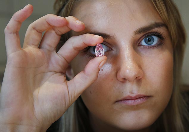 Funcionria de casa de leiles segura um raro diamante rosa de 8,41 quilates vendido por R$ 42,7 mi 