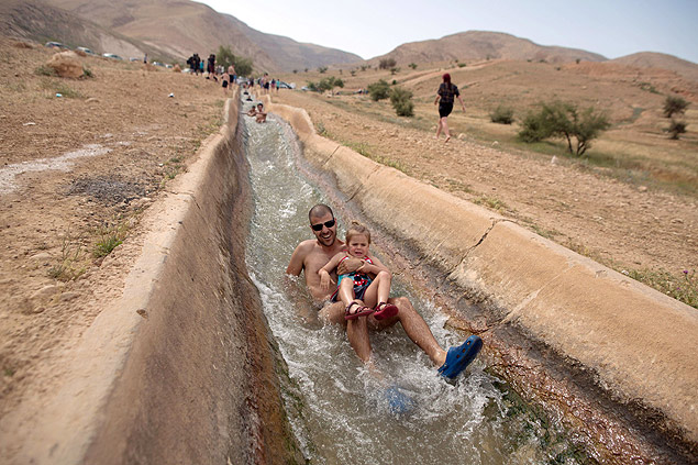 Colonos israelenses brincam em aqueduto na Cisjordânia durante feriado judaico