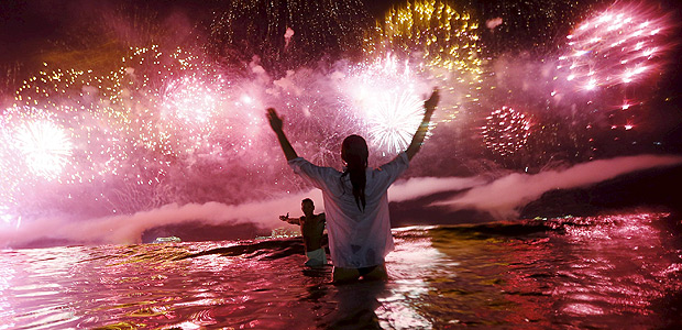 A couple watch as fireworks explode over Copacabana beach during New Year celebrations in Rio de Janeiro