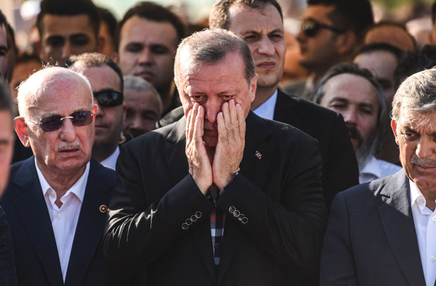 TOPSHOT - Turkey's President Recep Tayyip Erdogan (C) reacts after attending the funeral of a victim of the coup attempt in Istanbul on July 17, 2016. Turkish President Recep Tayyip Erdogan vowed today to purge the "virus" within state bodies, during a speech at the funeral of victims killed during the coup bid he blames on his enemy Fethullah Gulen. / AFP PHOTO / BULENT KILIC