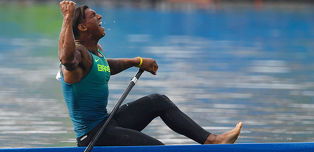 Brazil's Isaquias Queiroz Dos Santos celebrates after the Men's Canoe Single (C1) 1000m final at the Lagoa Stadium during the Rio 2016 Olympic Games in Rio de Janeiro on August 16, 2016. / AFP PHOTO / Damien MEYER