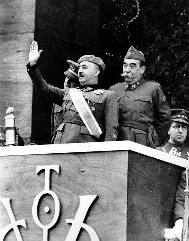O general Francisco Franco saúda o público durante Parada que celebra o fim da Guerra Civil Espanhola. A Espanha redemocratizou-se após a sua morte, em 1975 