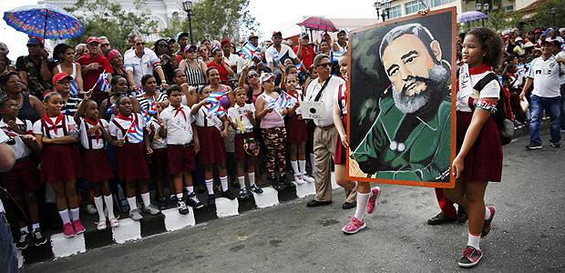 Schoolchildren wave Cuban flags as others carry a portrait of Cuba's late President Fidel Castro as the caravan carrying Castro's ashes arrives in Santiago de Cuba, Cuba, December 3, 2016. REUTERS/Carlos Garcia Rawlins ORG XMIT: HRB07