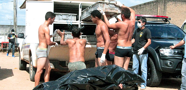 Presos carregam os corpos de detentos mortos em massacre na penitenciária de Monte Cristo, em Boa Vista