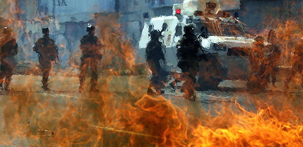 Venezuelan national guards walk behind a burning blockade during clashes with demonstrators during an opposition rally in Caracas, Venezuela, April 6, 2017. REUTERS/Marco Bello TPX IMAGES OF THE DAY ORG XMIT: CDG08