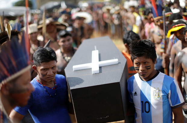 Brazilian Indians carry a symbolic coffin, to show the death of indigenous people's rights, as they take part in a demonstration against the violation of indigenous people's rights, in Brasilia