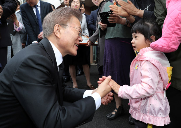 Novo presidente da Coreia do Sul, Moon Jae-in, cumprimenta criana ao deixar sua casa no dia da posse 