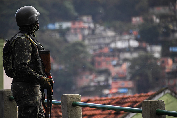 A soldier takes position at Morro do Macaco slum in Rio de Janeiro, Brazil, during a pre-dawn crackdown on crime gangs on August 5, 2017. Thousands of Brazilian army troops raided Rio de Janeiro slums leaving parts of the city looking like a war zone. Their main goal was to stop gangs behind a surge in brazen robberies of commercial trucks, with arrest warrants issued for 40 people. However, the unusually aggressive operation also follows wider concerns that nearly bankrupt post-Olympic Rio is spinning out of control. / AFP PHOTO / Apu Gomes