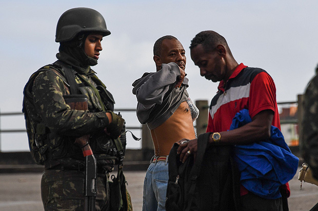 Soldado inspeciona mochila durante operao contra roubo de cargas na manh deste sbado, no Rio