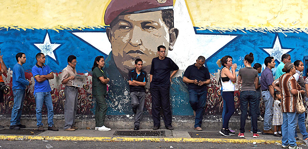 Venezuelanos em fila para votar em Caracas no domingo (15)