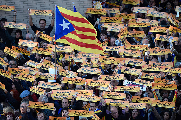 Um homem detm uma bandeira catal Pro-independncia Estelada, enquanto outros mantm placaris lendo "Liberdade" durante uma manifestao em Barcelona, em 11 de novembro de 2017, pedindo a libertao de lderes separatistas presos. Os legisladores optaram por se separar da Espanha, alegando ter um mandato aps um referendo em 1 de outubro, em que 90% dos eleitores apoiaram a secesso.