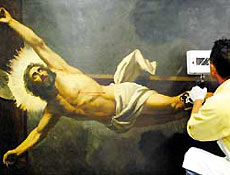 Restaurador trabalha na tela "Cristo Crucificado", do pintor Almeida Jnior