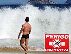 Mar bravio desestimula banho em Ipanema; no detalhe, placa alerta sobre perigo das águas