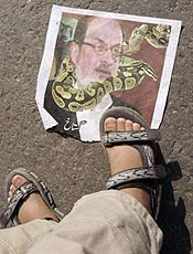 Rapaz protesta contra ttulo pisando em cartaz do escritor no Paquisto