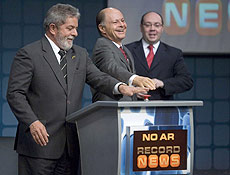 Lula e Macedo acionam boto; ao fundo, presidente da Record, Alexandre Raposo