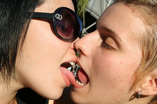 Com piercing na língua, meninas se beijam em festa. "Guia GLS São Paulo" traz atrações para público lésbico