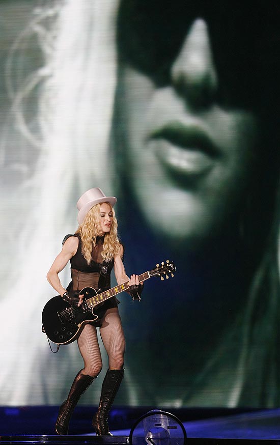 Madonna toca durante turnê "Sticky and Sweet" enquanto imagem de Britney Spears é projetada