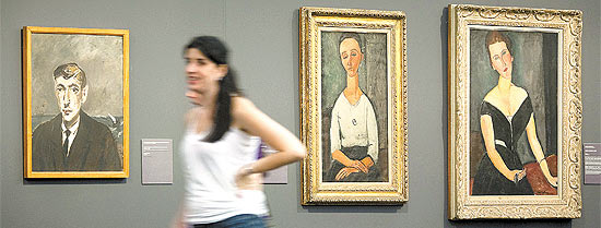Visitante em frente a pinturas de Filippo De Pisis (esq.) e Modigliani (centro e dir.), no Masp