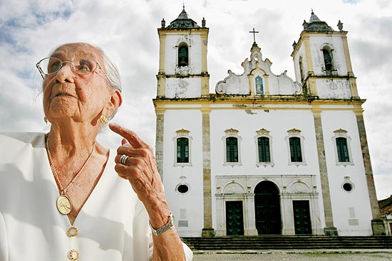 Claudionor Viana Telles Veloso, mais conhecida como Dona Cano, em frente a Igreja Nossa Senhora da Purificação, em Santo Amaro, Bahia.