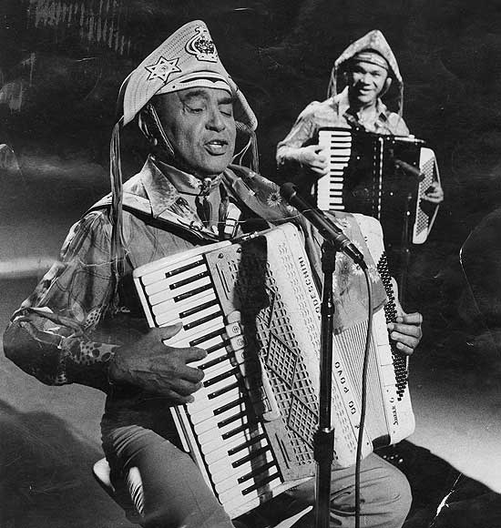 Texto: Música: o cantor e compositor Luiz Gonzaga, o Rei do Baião, e, ao fundo o acordeonista Dominguinhos em 1977. (Foto: Divulgação/TV Cultura)