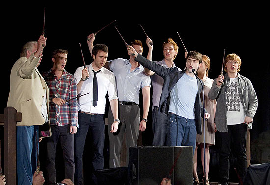 Daniel Radcliffe (front) and other members of the cast of Harry Potter wave their wands during the grand opening celebration for The Wizarding World of Harry Potter at the Universal Studio Resort in Orlando, Florida June 16, 2010. REUTERS/Scott Audette (UNITED STATES - Tags: ENTERTAINMENT)