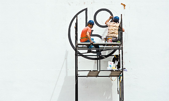 Operários pintam logotipo repaginado no prédio da Bienal