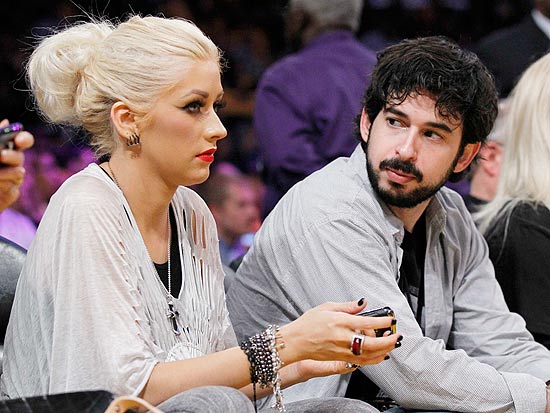 Christina Aguilera com expresso infeliz ao lado do ex-marido Jordan Bratman durante jogo de basquete em Los Angeles