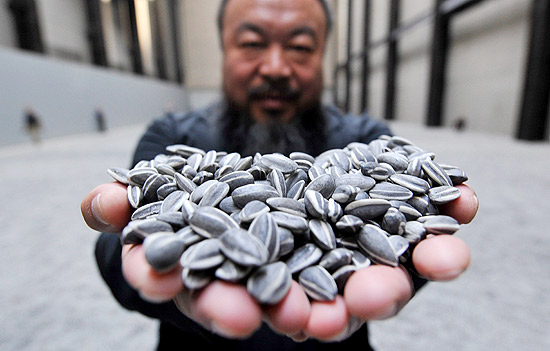 Artista Ai Weiwei segura um punhado de &quot;sementes&quot; de sua obra que foi fechada pela galeria Tate Modern