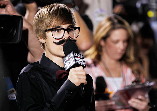 O cantor Justin Bieber com seu "disfarce" no tapete vermelho: bigode e óculos de grau