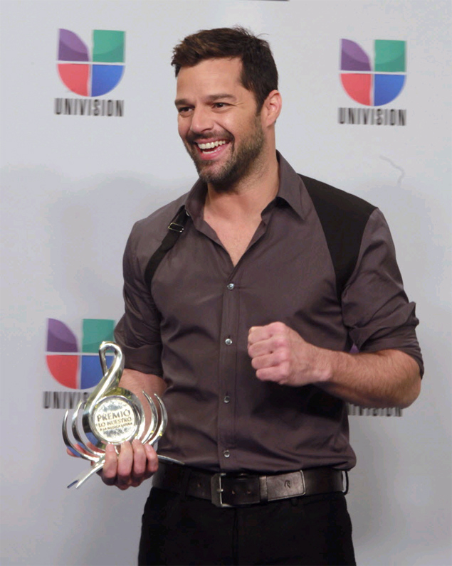 Cantor Ricky Martin posa para foto segurando o prmio de cone Mundial