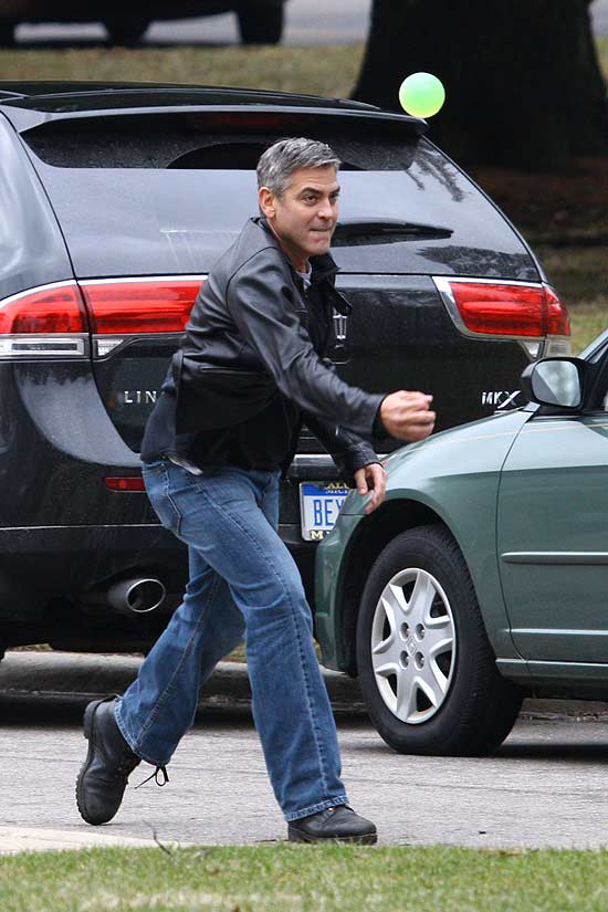 O ator e diretor George Clooney brincando com bola durante gravao de cena de funeral em Bloomfield Hills, nos EUA