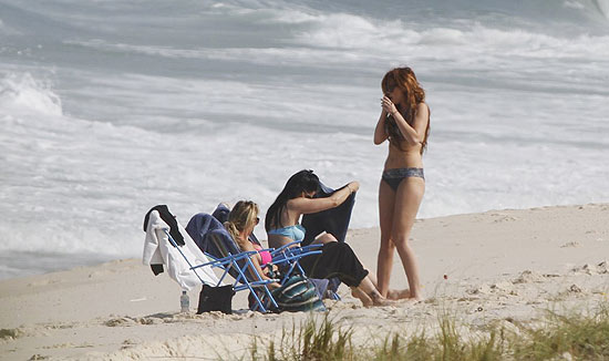 Miley Cyrus conversa com amigas na Praia da Reserva, no Rio de Janeiro, nesta quinta-feira
