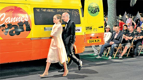 Pblico assiste a filme projetado em van que oferece cadeira e taa de vinho, em Cannes