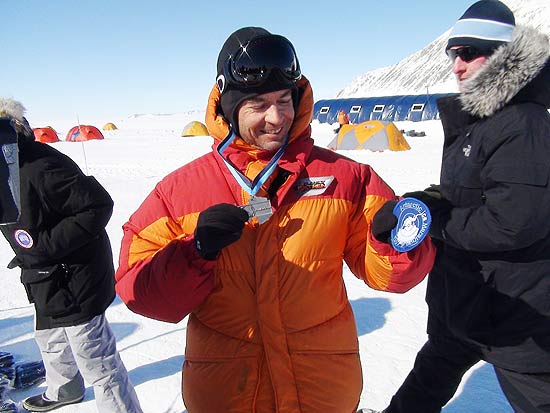 O repórter Clayton Conservani exibe medalha de maratona na Antártica durante cena do primeiro episódio da série '&#147;Planeta Extremo