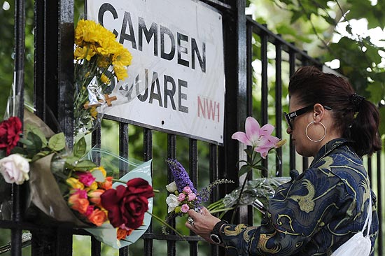 Mulher coloca flores em grade prxima  casa da cantora Amy Winehouse, encontrada morta neste sbado