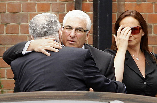 Ao centro, pai de Amy Winehouse, Mitch,  consolado durante velrio da filha nesta tera-feira