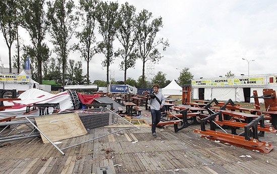 Homem passa por estrutura destruída do festival belga Pukkelpop; quatro pessoas morreram em decorrência da chuva