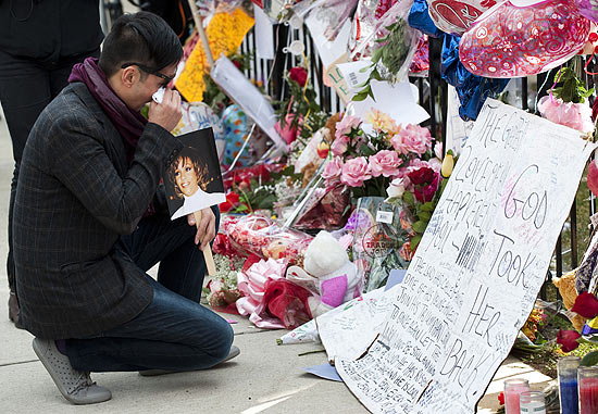 Fã se emociona ao homenagear Whitney Houston em frente à Igreja Batista New Hope, em Newark; veja mais fotos
