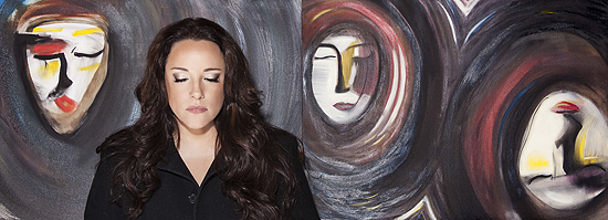 A cantora Ana Carolina em frente a dois quadros que pintou