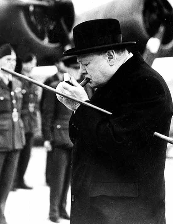 Winston Churchill (1874-1965), primeiro-ministro britnico, acende um charuto em fotografia sem data definida