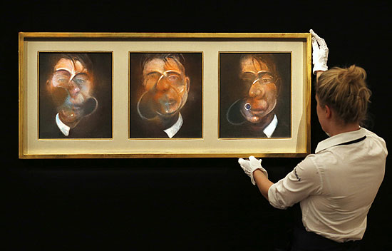 ORG XMIT: SLP109 A worker poses next to "Three Studies for a Self-Portrait" from 1980 by Francis Bacon, at Sotheby's in London January 31, 2013. The artwork is expected to sell for 10-15 million GB pounds (US$ 15.8-23.7 million) when auctioned at Sotheby's Contemporary Art evening auction in London on February 12. REUTERS/Suzanne Plunkett (BRITAIN - Tags: ENTERTAINMENT SOCIETY BUSINESS)