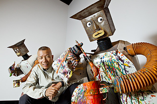 O artista Cai Guo-Qiang entre robôs pintores