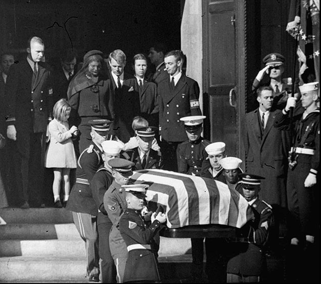 Robert Kennedy (de terno, de cabeça baixa) com viúva e filhos pequenos de JFK