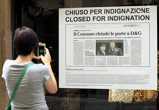 Garota fotografa cartaz em loja da Dolce e Gabbana, em Milo, com dizeres: "Fechado por indignao"